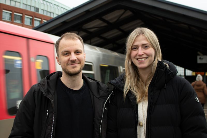 Foto von zwei Personen vor einer U-Bahn.