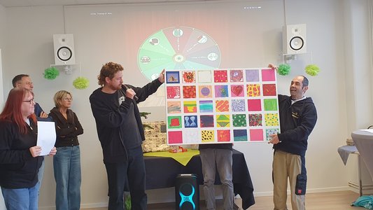 Ein Mitarbeiter und ein Klient halten ein großes Bild hoch.