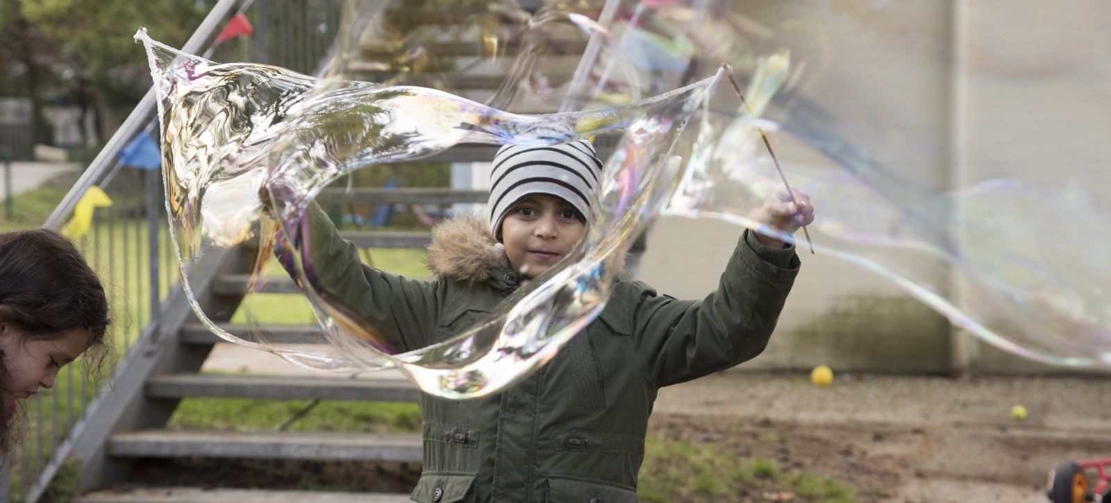 Ein Kind macht Riesenluftblasen.