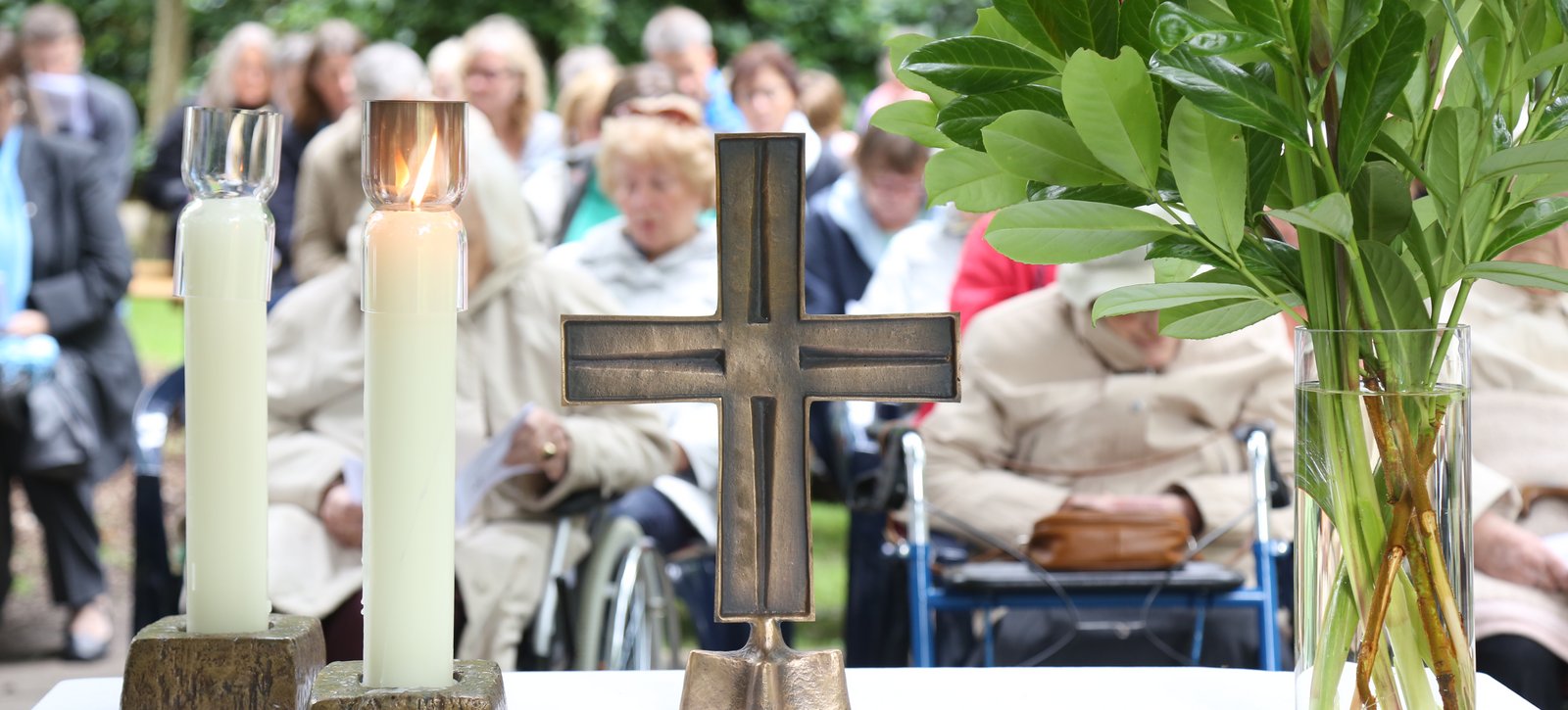 Kerzen und Kreuz auf dem Altar beim Sommersegen auf dem Stiftungsgelände