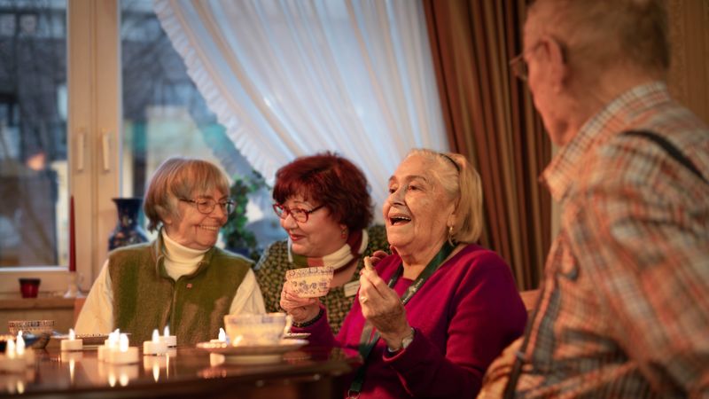Senioren am Tisch erzählen und lachen.
