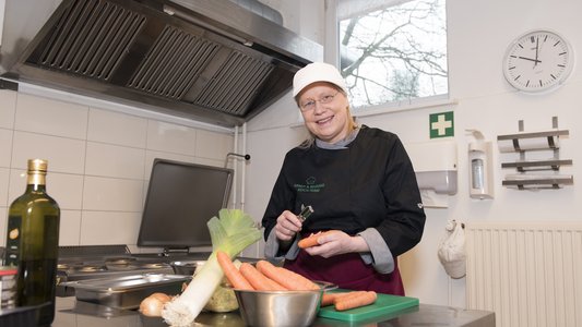 Eine Frau bereit Speisen zu.