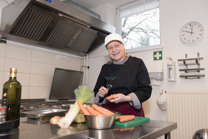 ALa im Bereich Küche Eine Frau bereit Speisen zu.