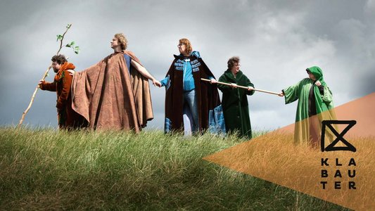 Menschen überwinden einen Berg, halten sich aneinander fest.