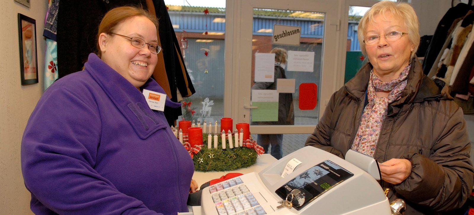 Eine Frau an der Kasse mit einer Kundin
