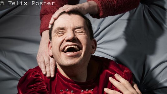 Mehrere Hände streicheln Mann, der lächelt