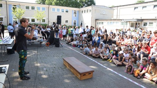 Die Schülerinnen und Schüler warten gespannt auf ihre Ehrung.