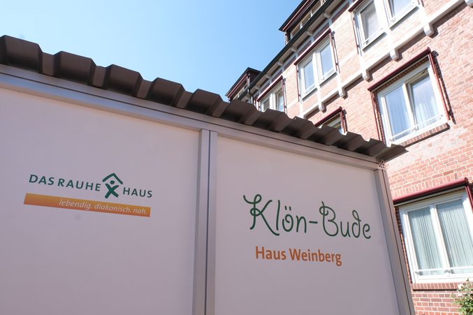 Die Klön-Bude steht vor dem Haus Weinberg. Zwei Menschen können in der Box miteinander sprechen.