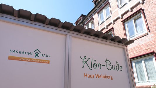 Die Klön-Bude steht vor dem Haus Weinberg. Zwei Menschen können in der Box miteinander sprechen.