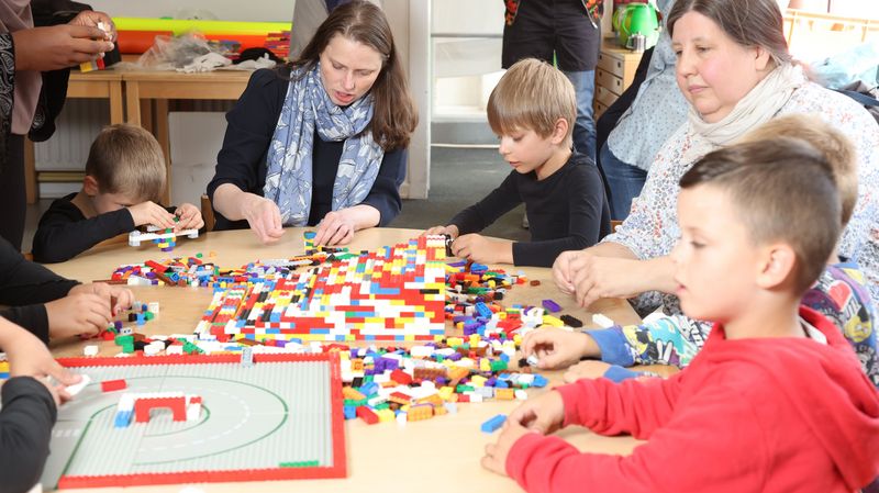 Sozialsenatorin Leonhardt baut zusammen mit Kindern eine Legorampe.