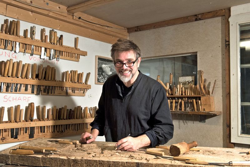 Der Bildhauer Hauke Jessen steht an der Werkbank in seiner Werkstatt.